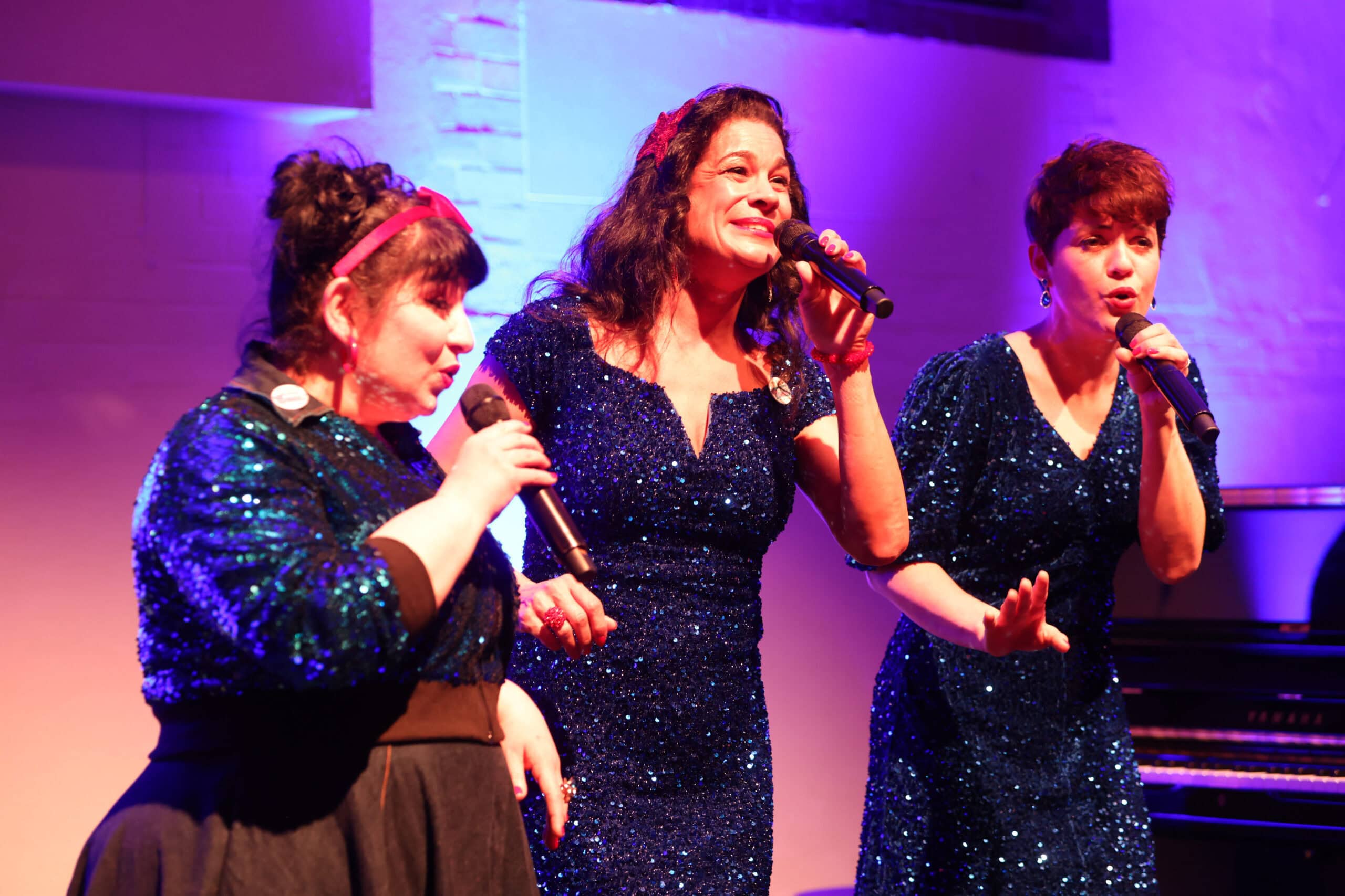 Caroline Kiesewetter und die Ohnsorg-Süsters singen beim Neujahrsempfang der Stiftung Kinderjahre in Hamburg auf der Bühne.