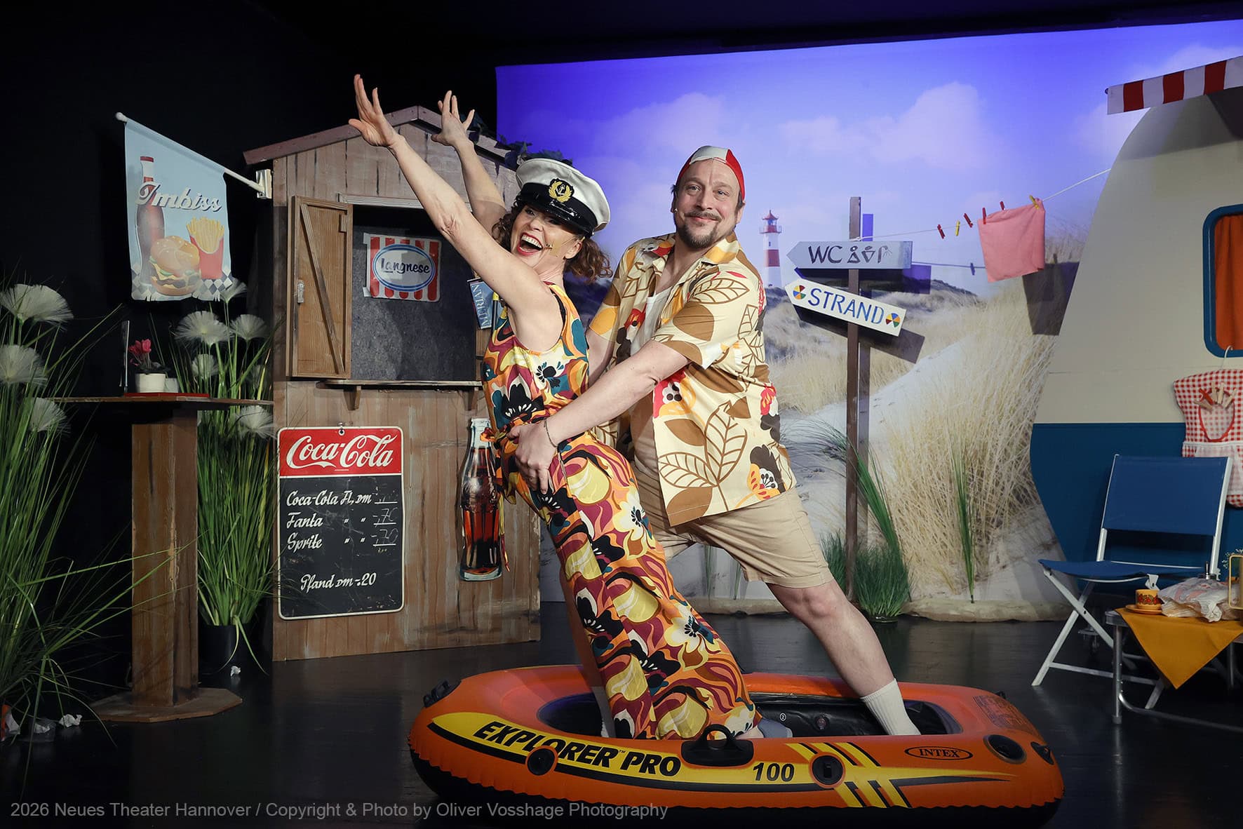 Szene aus „ABER BITTE MIT SCHLAGER“ im Neues Theater Hannover: In farbenfrohen 70er-Jahre-Kostümen und mit viel Spielfreude sorgt das Ensemble vor nostalgischer Campingplatz-Kulisse für ausgelassene Urlaubsstimmung zwischen Strand, Schlagern und sommerlicher Leichtigkeit. Foto: Oliver Vosshage