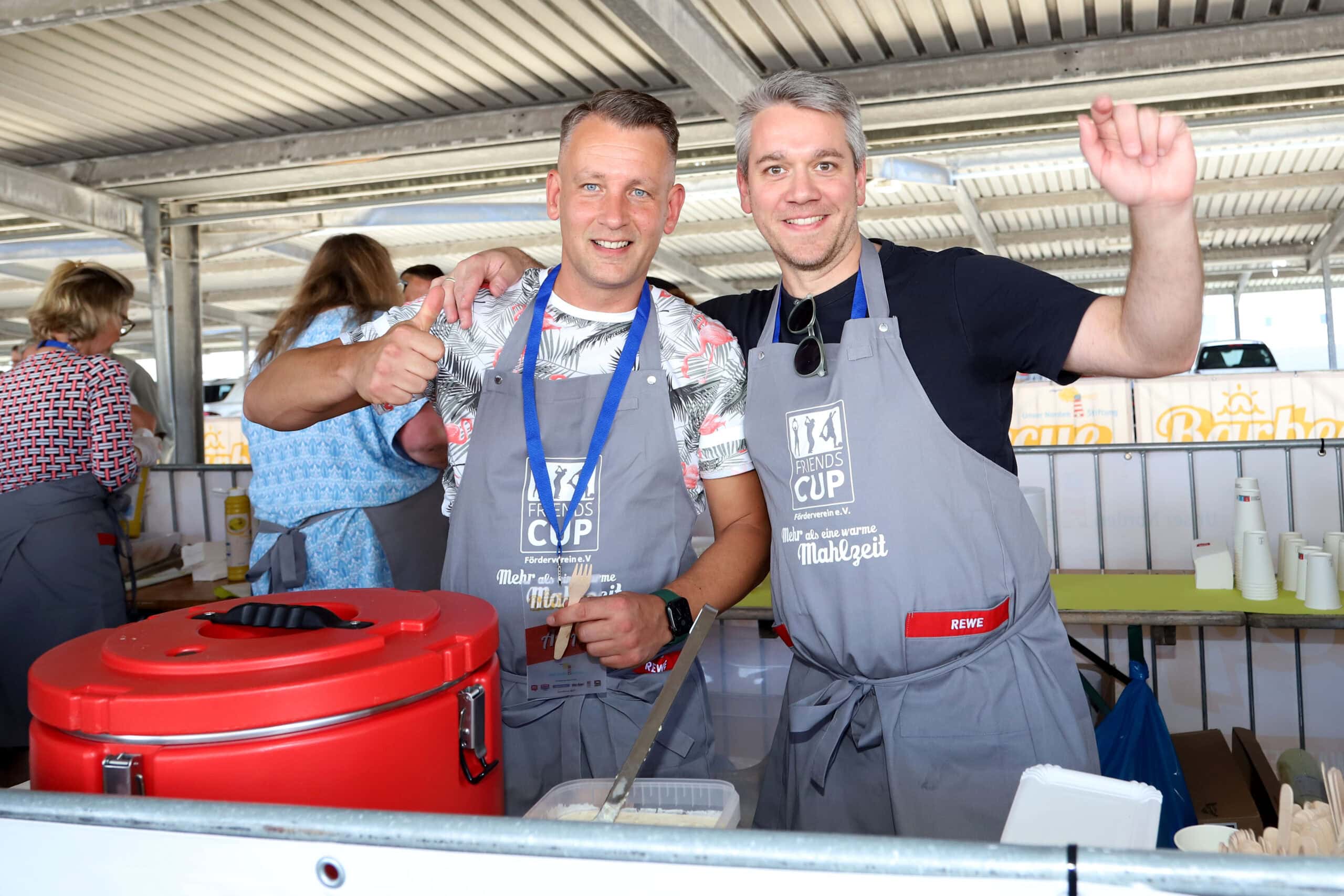 Marcus Schelbert vom NYX Hotel und Andreas Piepereit vom Nikolai Hotel unterstützten das FRIENDS-CUP-Sommerfest in Hamburg-Altona tatkräftig bei der Ausgabe von Nudelsalat an die Gäste. Foto: Heike Ross.