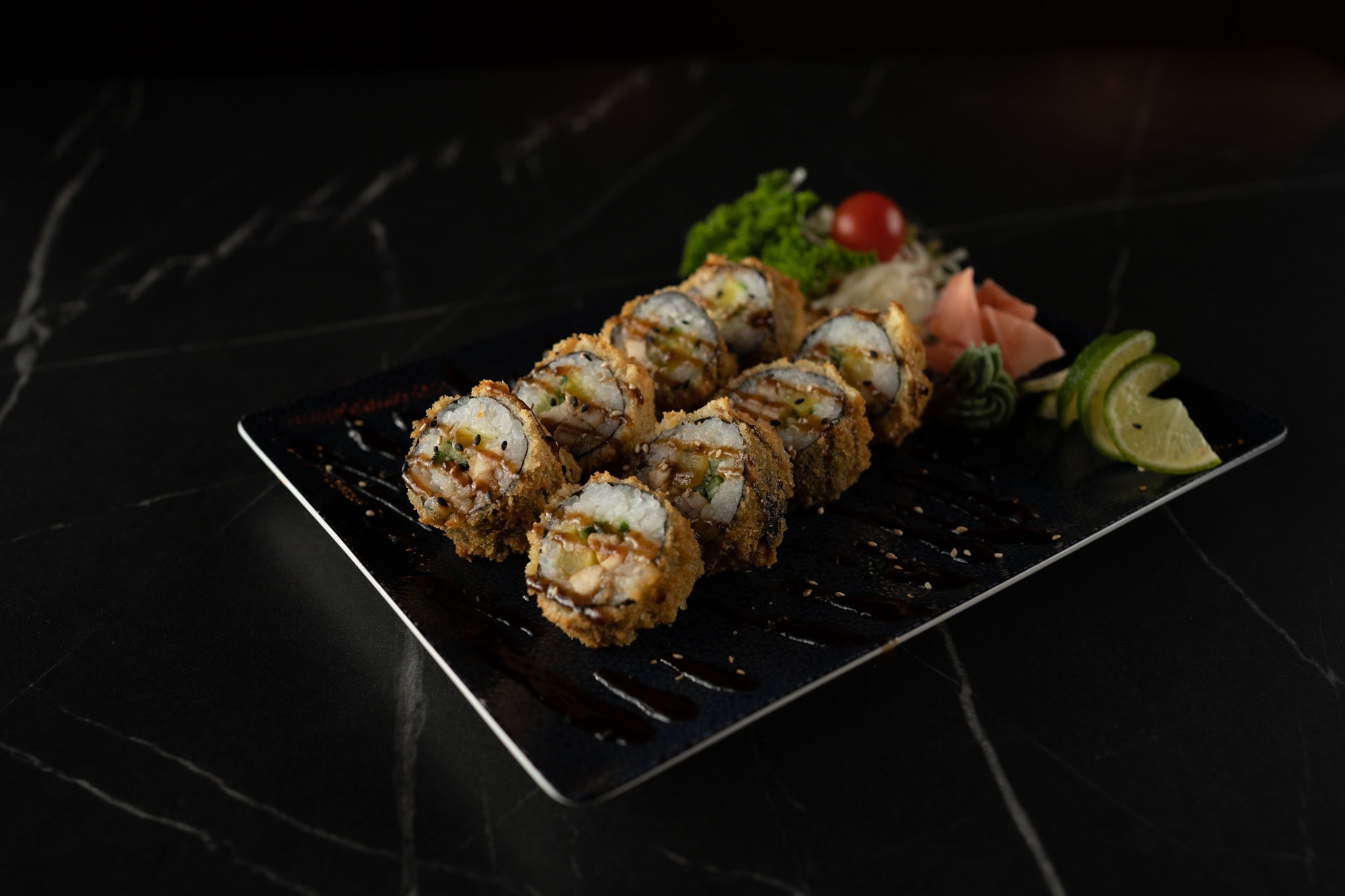 Crunchy Sushi Roll mit Lachs und Avocado auf schwarzem Teller im Mister Q Hannover.