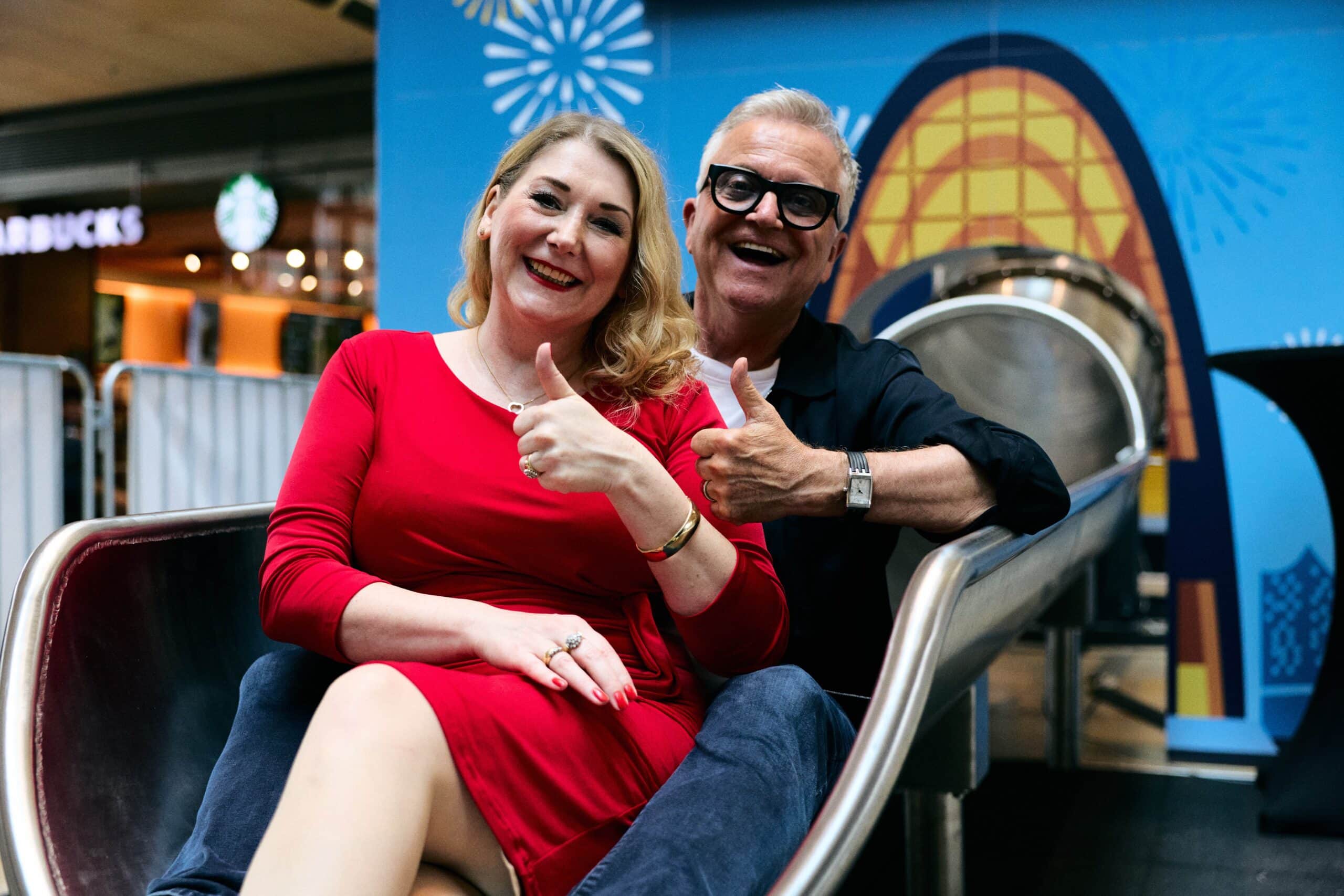 Schauspielerin Sandra Quadflieg und Künstler Jörg Knör zeigen sich nach der gemeinsamen Fahrt auf Europas längster Indoor-Rutsche in der Europa Passage begeistert
