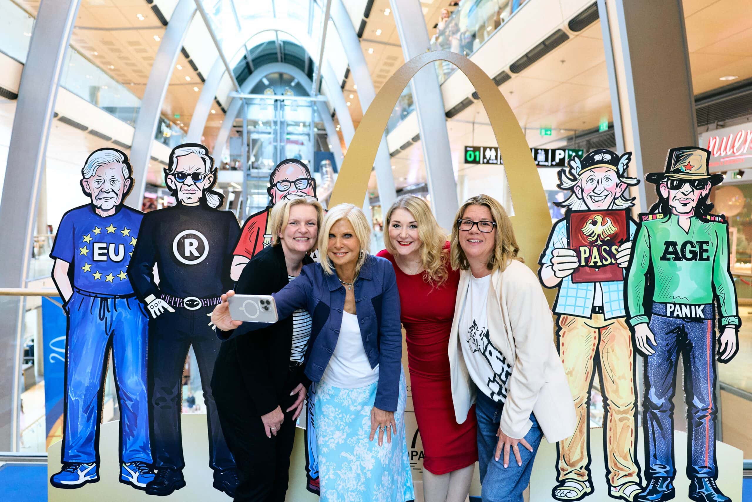 Martina Müller, Babette Greif, Sandra Quadflieg und Claudia Schulz nutzen den neuen Promi-Selfie-Point der Europa Passage mit Karikaturen bekannter Hamburger Persönlichkeiten für ein gemeinsames Erinnerungsfoto.